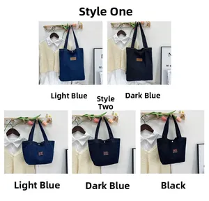 Detail view of denim tote bags in black and blue colors with vintage embroidery patches