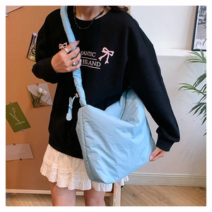 Vue détaillée du sac bandoulière en nylon matelassé bleu clair avec sangle large