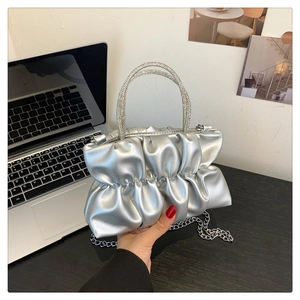 Silver pleated cloud bag with rhinestone circular handle and delicate chain strap detail