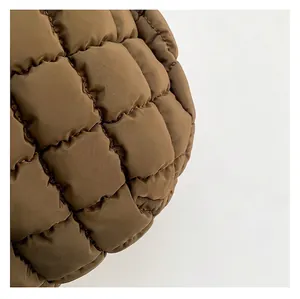 Close-up of brown quilted puffer fabric texture with square stitching and satin finish