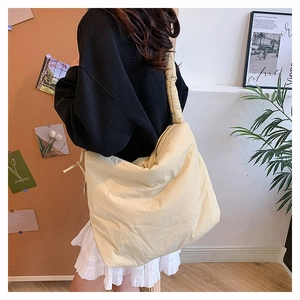 Détail du sac bandoulière tendance en nylon matelassé beige avec large bandoulière