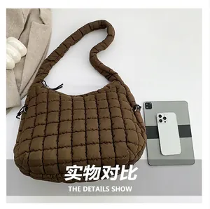 Brown quilted shoulder bag shown with tablet to demonstrate large storage capacity