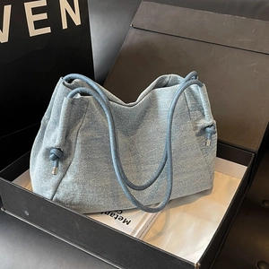 Minimalist light blue denim tote bag with knotted rope handles in a stylish gift box