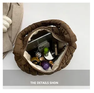 Spacious interior of coffee brown quilted puffer bag holding a tablet, phone and umbrella