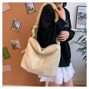 Détail du sac bandoulière en nylon blanc cassé avec sa large bandoulière souple et froncée