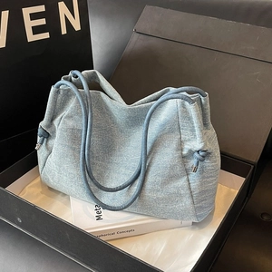 Minimalist denim blue tote bag with drawstring detail in a black gift box packaging