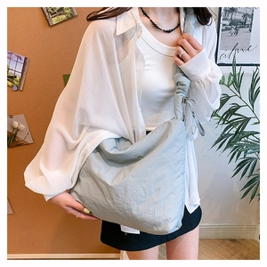 Détail du sac bandoulière en nylon bleu clair avec texture plissée et bandoulière froncée