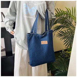 Detailed view of deep blue denim tote bag with leather embroidery and large capacity
