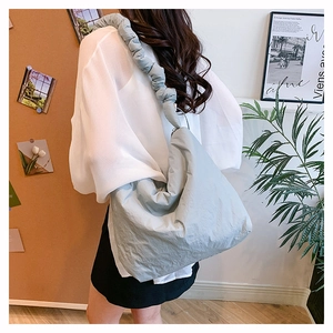 Vue détaillée du sac bandoulière en nylon bleu clair avec plis froncés sur la large bandoulière