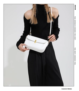Detail view of a white PU leather crossbody bag featuring gold hardware and a metal buckle