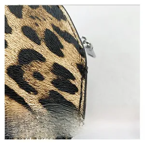 Macro shot of leopard print faux leather texture with silver metal zipper detail