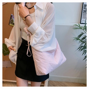 Détail du sac à bandoulière en nylon rose clair avec bandoulière froncée à cordon
