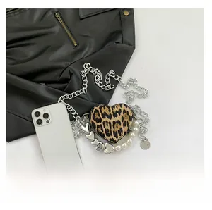 Detail of leopard print heart-shaped bag with silver chain and white faux pearls