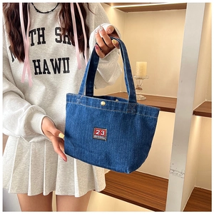 Detail of blue denim tote bag featuring vintage red and white number 23 embroidery