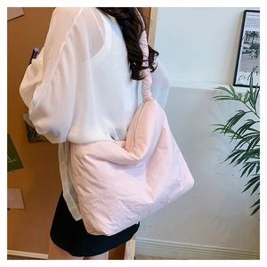 Détail du grand sac cabas rose clair en nylon avec bandoulière plissée élégante