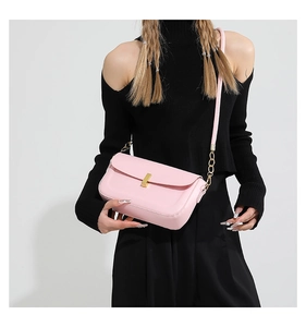 Detail of light pink PU leather crossbody bag with golden square twist lock and chain strap