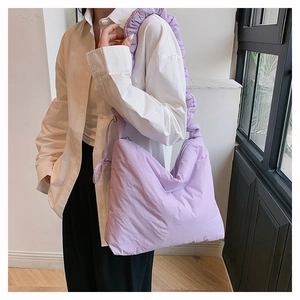 Détail du sac bandoulière matelassé en nylon lavande avec bandoulière plissée élégante