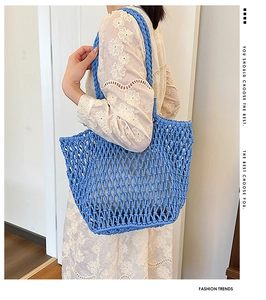 Detail of blue hand-woven tote bag with mesh pattern and wide braided handles