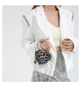 Close-up of heart-shaped leopard print mini bag with pearl handle and silver chain