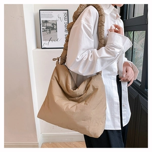 Détail du sac à bandoulière en nylon kaki avec texture plissée et sangle froncée