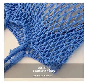 Close-up of blue woven hand-knotted mesh handbag showing fine stitching and fabric lining