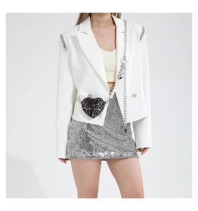 Detail of trendy heart-shaped leopard print waist bag with pearl and chain on white blazer
