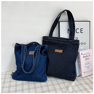 Detailed view of durable denim tote bags with leather patches on checkered fabric