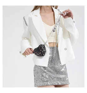 Detail of heart-shaped leopard print mini bag featuring pearl and chain strap on model