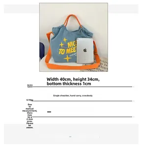 Dettaglio borsa in denim 40x34cm con manici arancioni e iPad per scala dimensioni