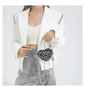 Close-up of leopard heart-shaped bag with pearl handle and silver chain strap