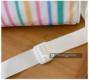 Detail of colorful striped nylon shoulder bag featuring a white adjustable woven strap