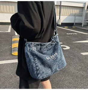 Close-up of vintage blue denim crossbody bag featuring white JLX BAG letter printing