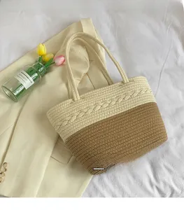 Close-up detail of two-tone woven straw tote bag with textured patterns for beach holiday