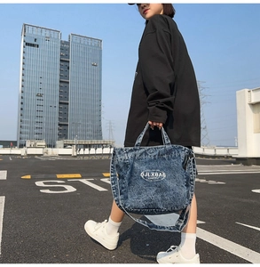 Detail shot of vintage washed denim tote bag with letter print and dual shoulder straps
