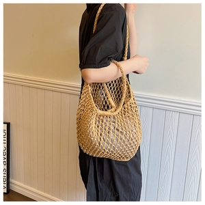 Khaki woven straw tote bag with inner pouch shown as a stylish shoulder bag for women
