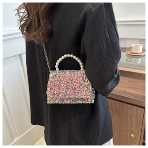 Detail of sequin handbag with pink gradient finish and elegant pearl top handle