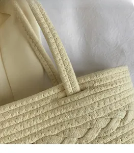 Detail of wide shoulder strap and beige woven texture on stylish crossbody bag