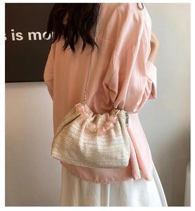 Détail du sac bandoulière en paille tressée avec perles roses et bandoulière chaîne argent
