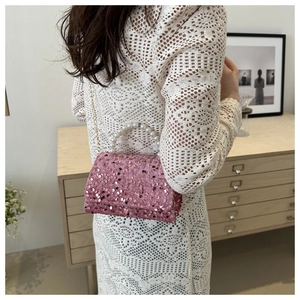 Detailed view of pink sequin handbag with pearl handle and golden chain strap for women