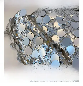Macro shot of silver sequin fabric detailing with dual-layered reflective textures