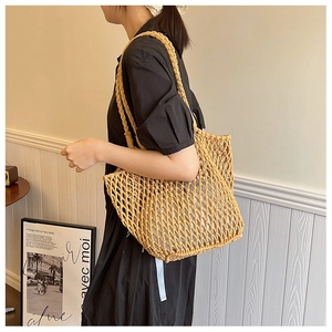 Close-up of yellow woven mesh tote bag with thick shoulder straps and white lining