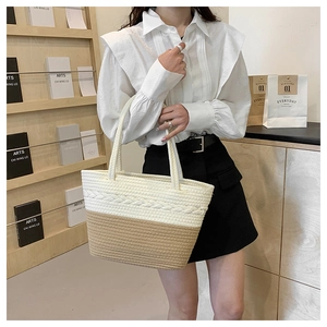 Detail of woven straw tote bag with braided textures and bicolor fiber pattern