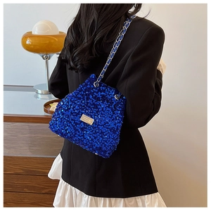 Detail of blue sequined crossbody bucket bag with elegant chain strap on shoulder