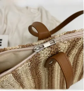 Close-up of the smooth zipper closure on this vintage striped woven straw tote bag