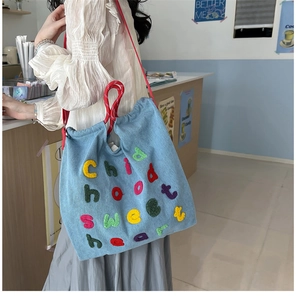 Dettaglio borsa a tracolla in denim con ricamo Childhood Sweetheart e manico in corda rossa