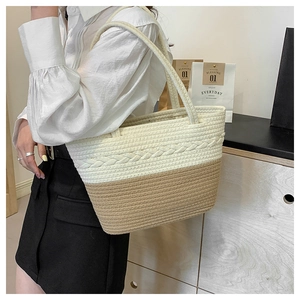 Detail of woven tote bag with cream and khaki contrast texture and rope handles