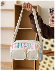 Detailed close-up of rainbow gradient nylon shoulder bag with zip pockets and KAI ZHUO logo