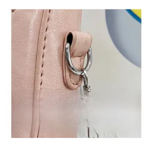 Detail of light pink pebble leather bag featuring silver metal D-ring and fine stitching