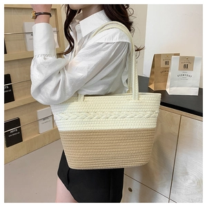 Detail shot of a hand-woven tote bag showing bi-color cream and khaki fiber texture