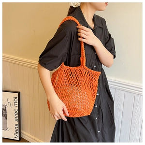 Close-up of orange woven mesh tote bag with thick handles for beach and summer vacations